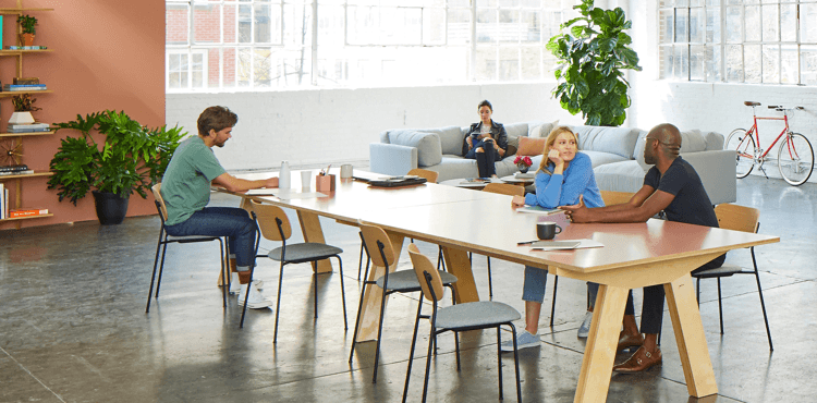 Vyklízení kanceláří, lidé pracující u stolu v moderní kanceláři