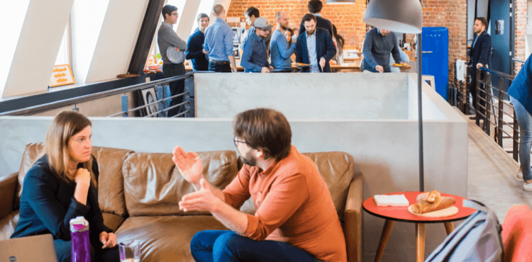 Lidé v kanceláři při diskuzi a práci ve skupinách.